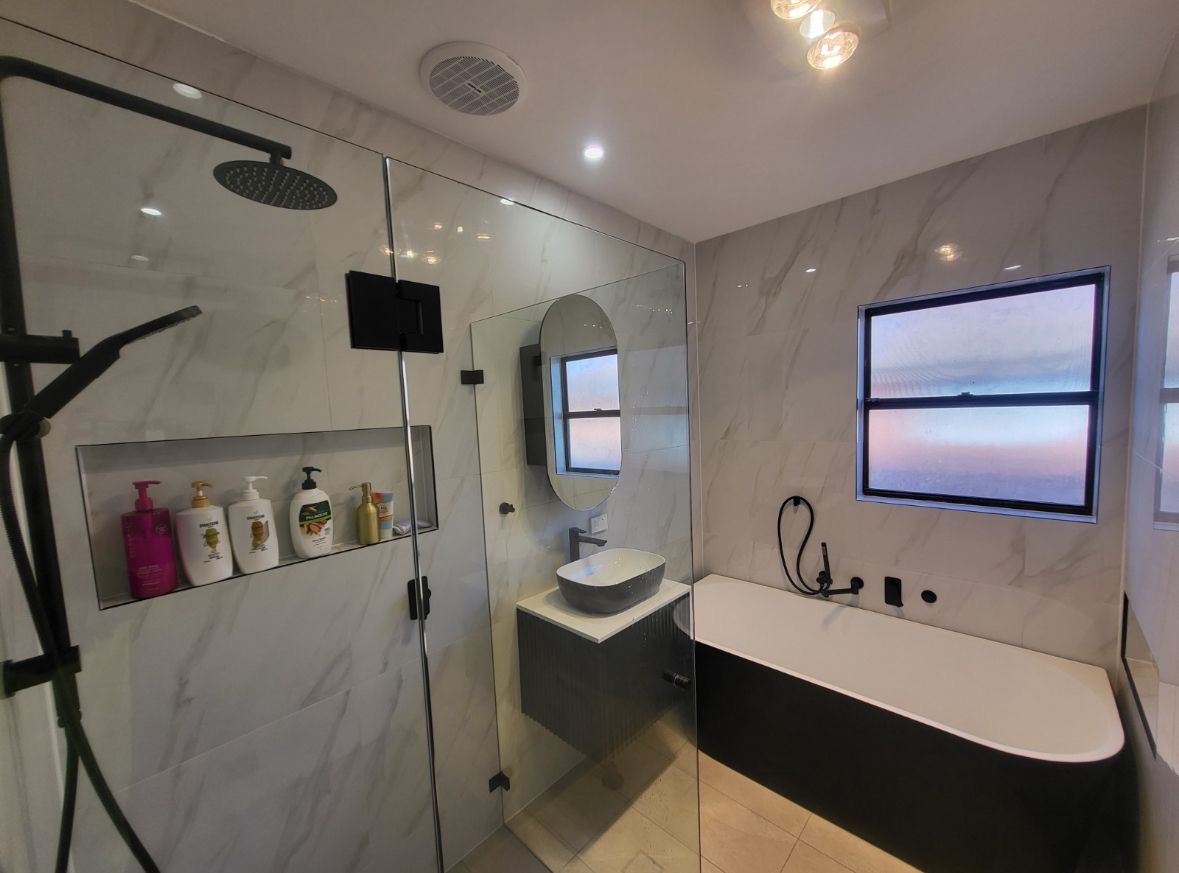 Marble bathroom with matte black tapware and freestanding bath